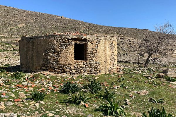 Κυκλική λίθινη υποδομή με φόντο τον καταυλισμό στα πρανή